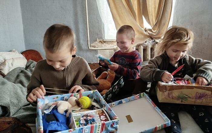 Kinder packen Geschenke mit Herz aus