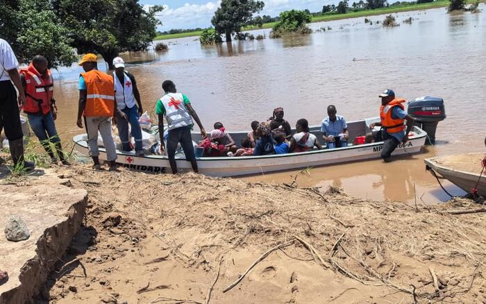 Ein Boot mit geretteten Meschen liegt um Ufer eines überschwemmten Gebietes in Mosambik