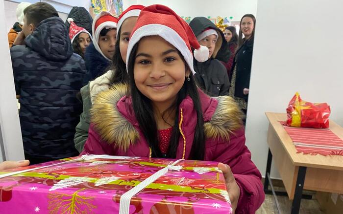 Mädchen hält ihr Päckchen der humedica-Aktion Geschenk mit Herz in die Kamera