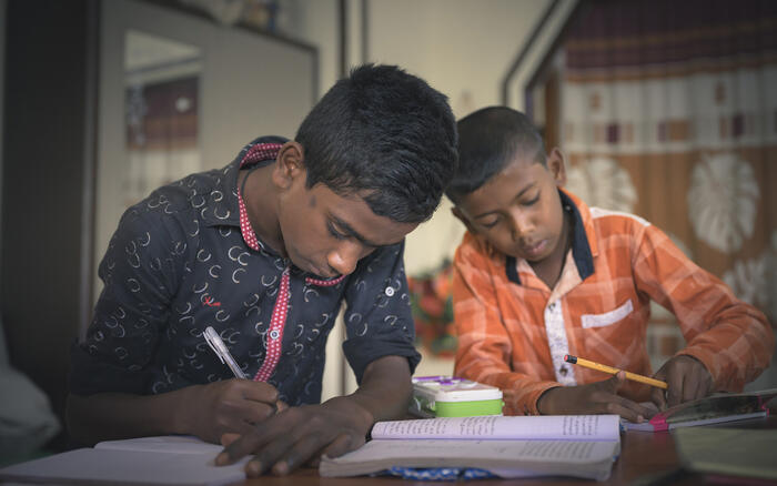 Zwei Schuljungen schreiben in ihre Hefte