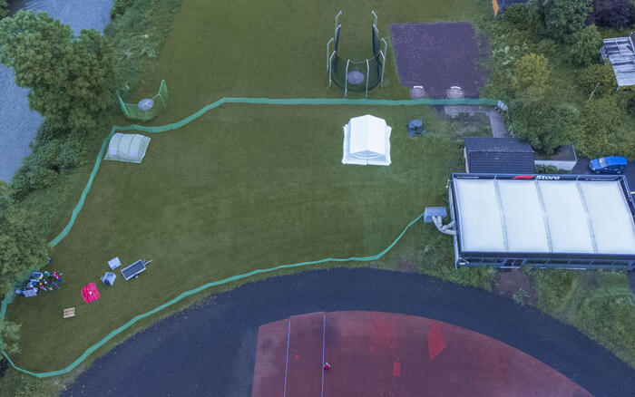 Luftbildaufnahme einer abgegrenzten Wiese mit Zelt