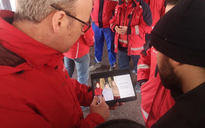 Ein Mann mit humedica-Jacke zeigt einem anderen etwas auf dem Tablet