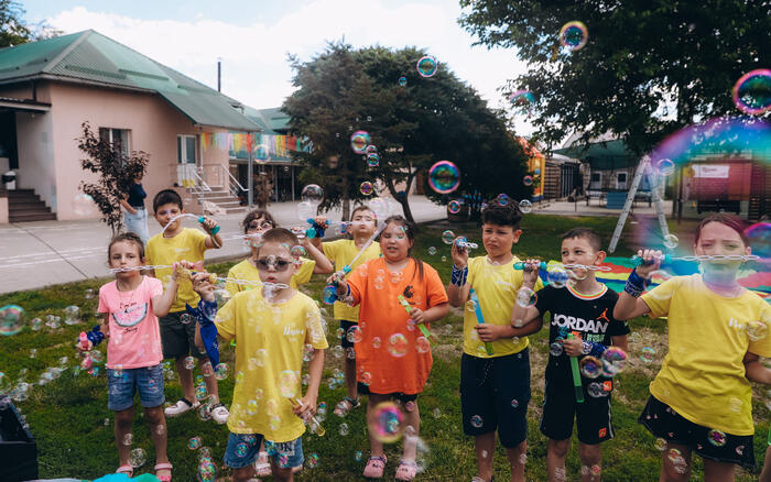 Eine Gruppe Kinder bläst Seifenblasen in die Luft