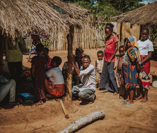 Erwachsene und Kinder stehen vor einem Haus