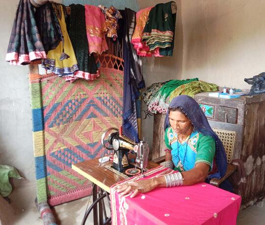 Eine Frau aus Pakistan arbeitet an ihrer Nähmaschine