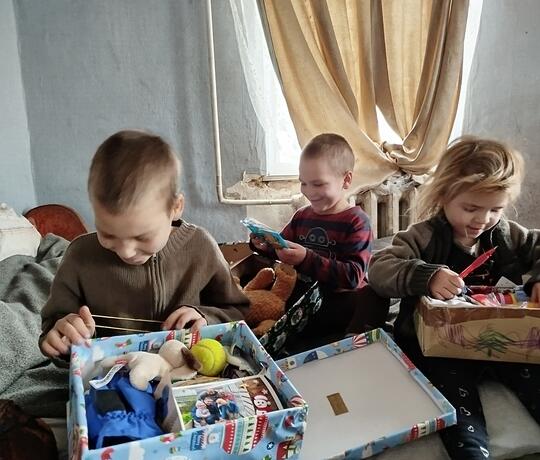 Kinder packen Geschenke mit Herz aus