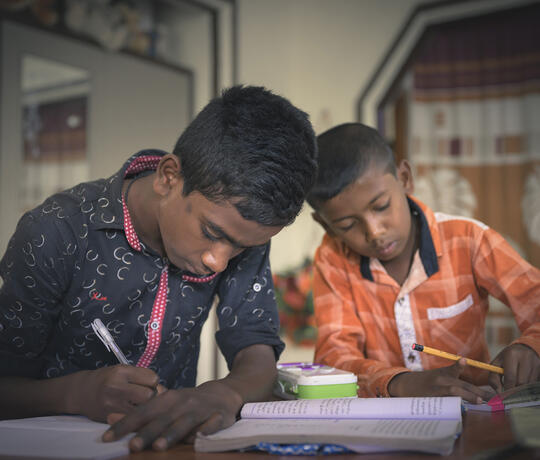 Zwei Schuljungen schreiben in ihre Hefte