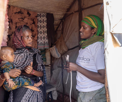 Eine humedica-Mitarbeiterin spricht mit einer Mutter mit Kind in Äthiopien