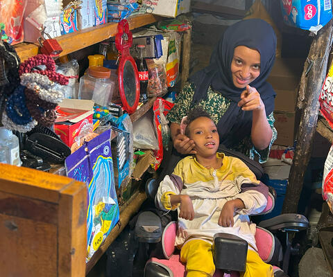 Ein Kind im Rollstuhl und seine Mutter schauen in die Kamera in Äthiopien