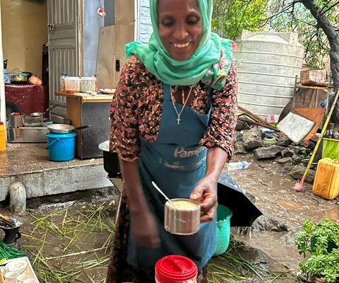 Eine äthiopische Frau schenkt an ihrem Verkaufsstand Getränke ein