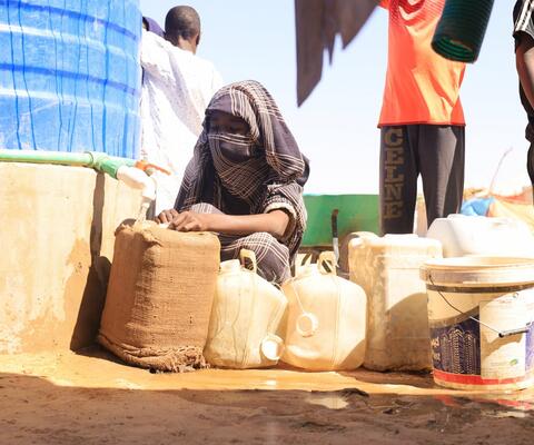 Ein Mädchen füllt einen Wasserkanister auf.