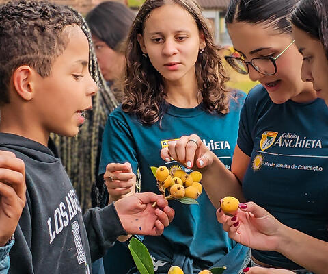 Studenten halten einen Zweig mit Wollmispeln in der Hand