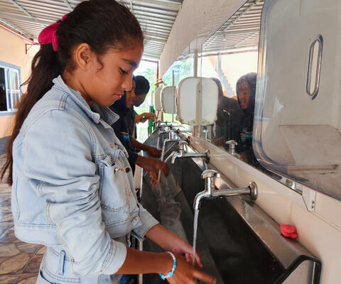 A girl washes her hands