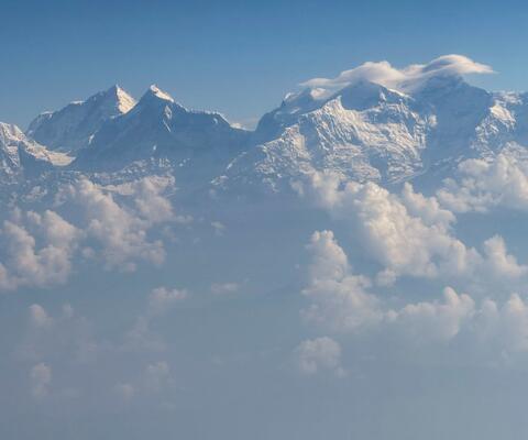 Über den Wolken schauen schneebedeckte Gipfel des Himalaya hervor