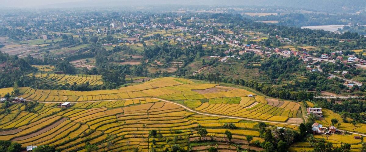 Landschaftsaufnahme Reisfelder, Siedlungen und Fluss in Nepal