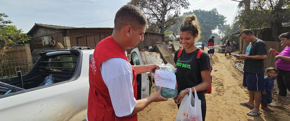 Mitarbeiter von humedica uebergibt Hilfsgueter an Menschen im Katastrohpengebiet