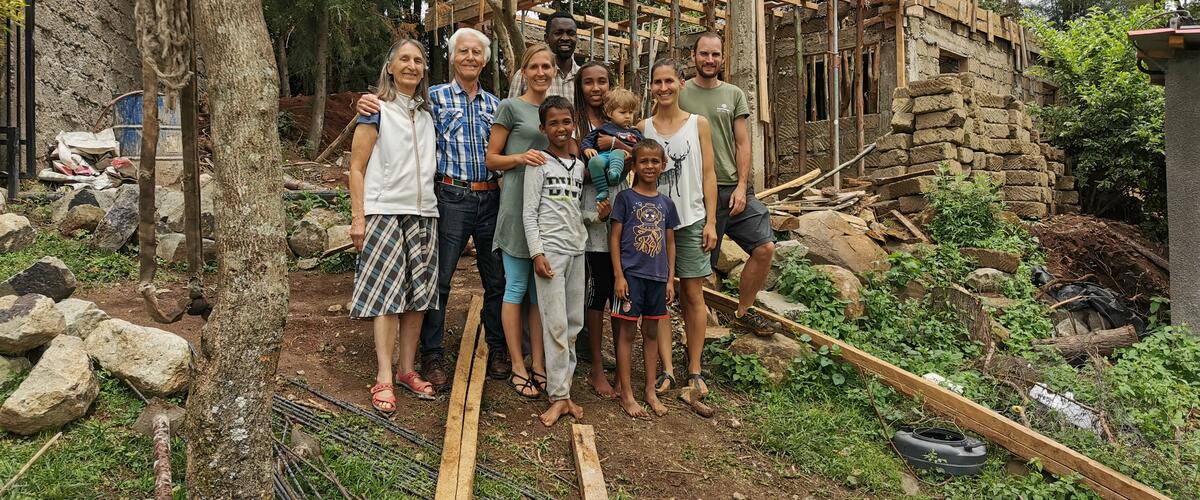 Dominik Landgraf steht mit seiner Familie vor dem Haus in Kenia