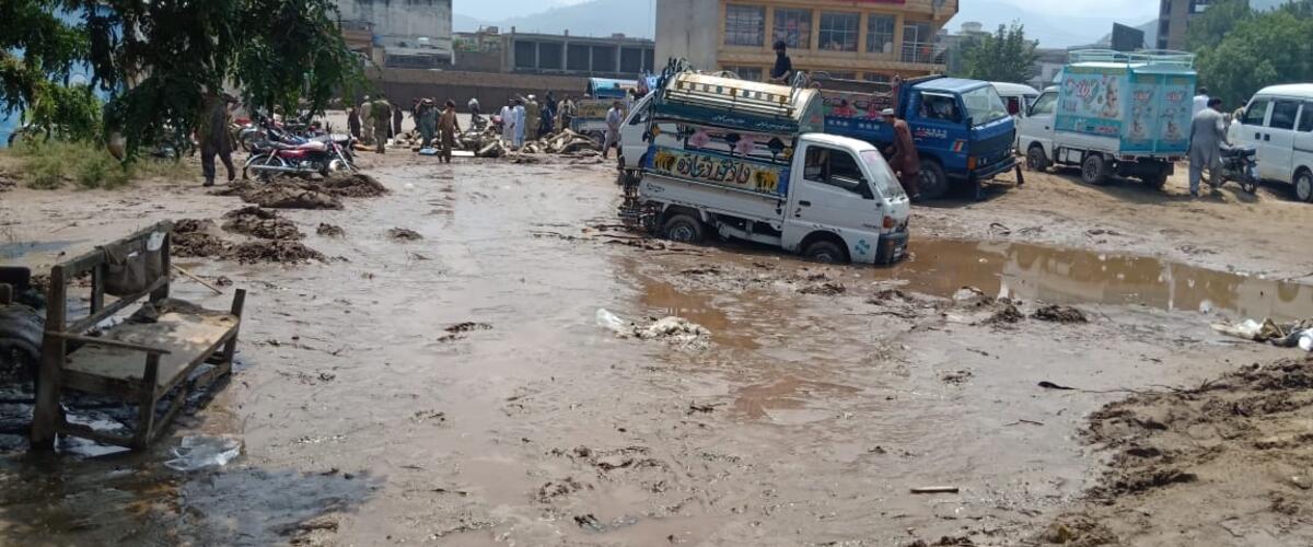Autos und Menschen in überfluteter Stadt