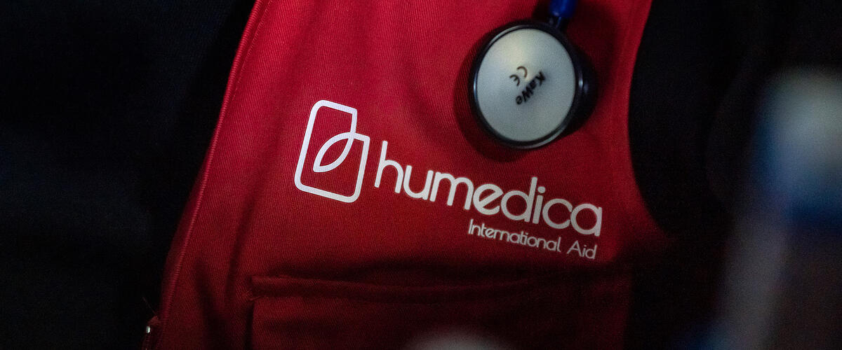 Ausschnitt einer roten Weste mit humedica-Logo über dem ein Stethoskop hängt