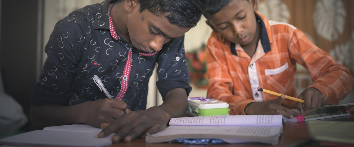 Zwei Schuljungen schreiben in ihre Hefte