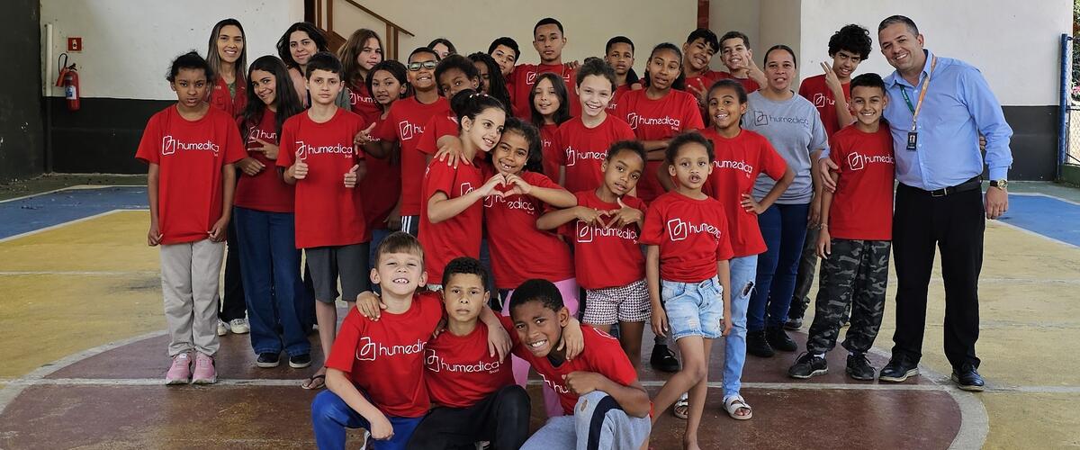 Kinder mit rotem humedica-T-Shirt stehen in einer Turnhalle