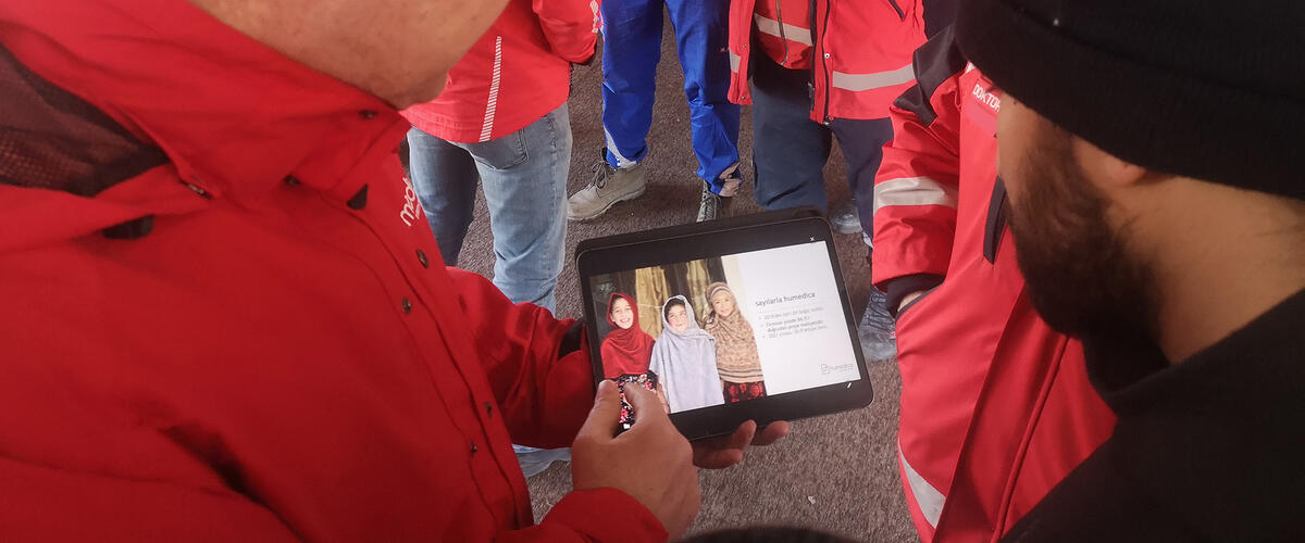 Ein Mann mit humedica-Jacke zeigt einem anderen etwas auf dem Tablet