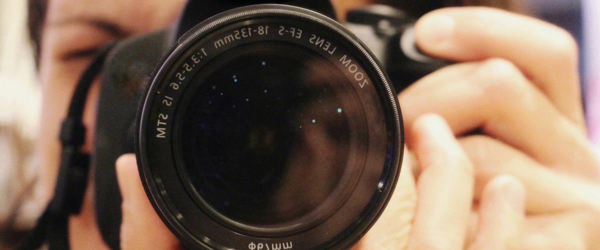 Objektiv einer Kamera auf den Betrachter gerichtet