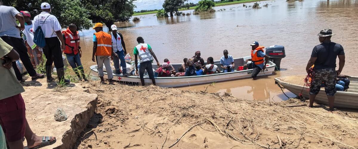 Ein Boot mit geretteten Meschen liegt um Ufer eines überschwemmten Gebietes in Mosambik