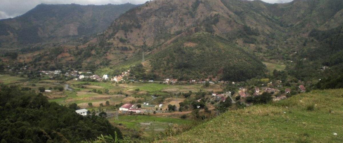 In einer grünen Hügellandschaft befinden sich Häuser.