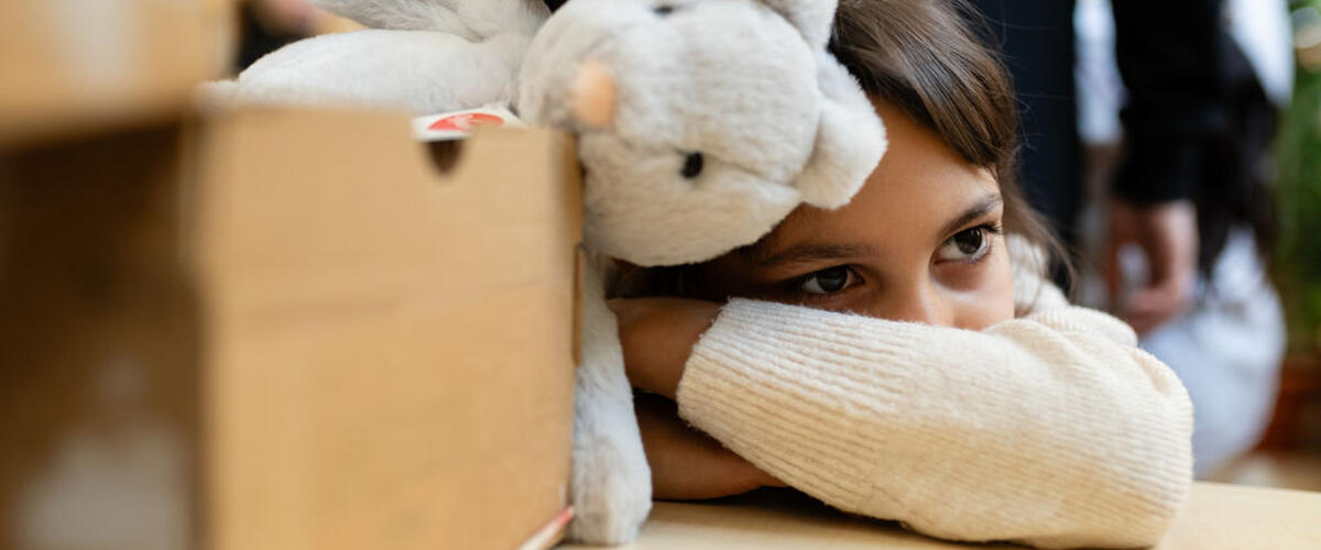 verträumtes Kind mit Kuscheltier