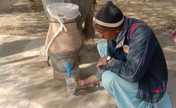 Mann benutzt Wasserfilterstation in Pakistan