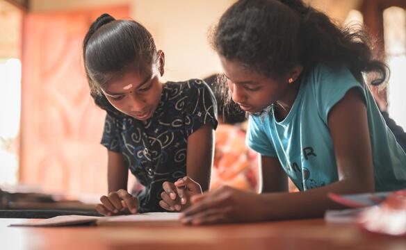 Zwei Mädchen schauen auf ein Heft in Sri Lanka