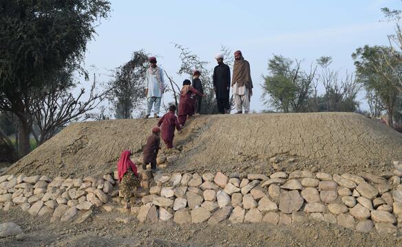 Menschen besteigen Schutzwall in Pakistan