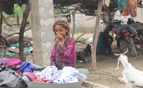 Mädchen lacht in notdürtiger Behausung in Pakistan