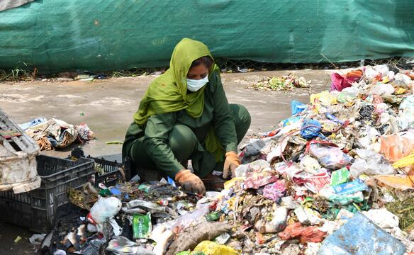 Frau sortiert Müll in Pakistan