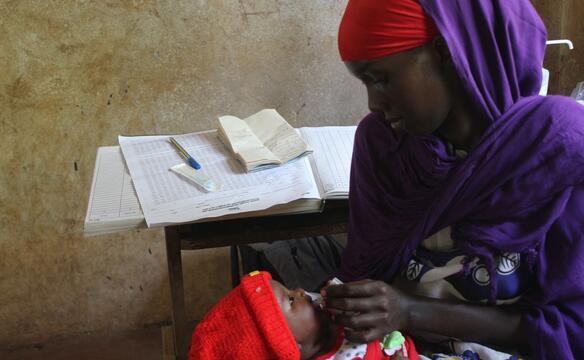 Frau verabreicht Baby Flüssigkeit in Kenia