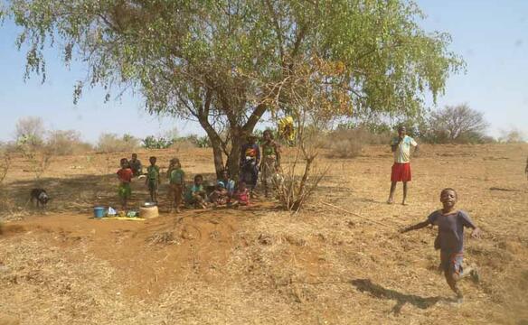Familie in Madagaskar sucht Zuflucht vor Sonne unter Baum
