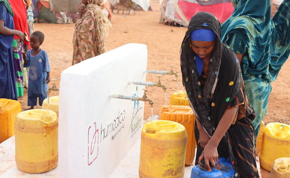 Afrikanische Frau holt Wasser an Brunnen