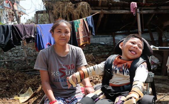 Mutter sitzt neben ihrem behindertem Kind