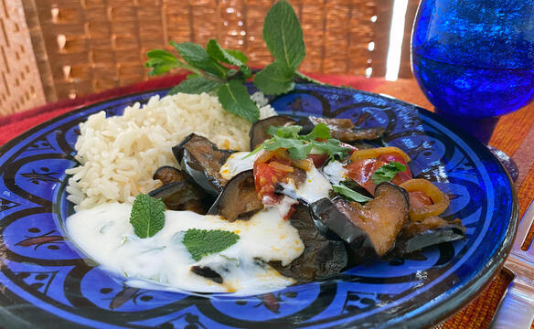 Borani Banjan auf einem Teller mit Joghurtsoße angerichtet