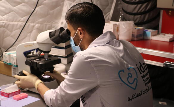 A man looks through a microscope