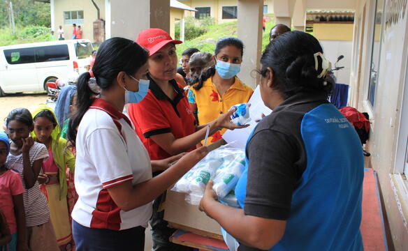 Frauen verteilen Hilfsgüter in einer Notunterkunft in Sri Lanka nach dem Wirbelsturm Ditwah