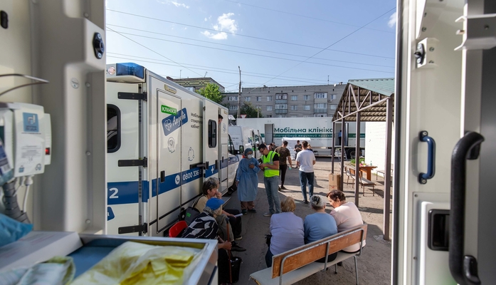 Menschen warten vor mobiler Klinik auf Behandlung in der Ukraine